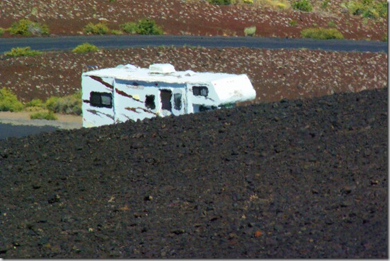 Class C Motorhome seen through heated air rising off of black cinders on Inferno Cone at Craters of the Moon National Monument