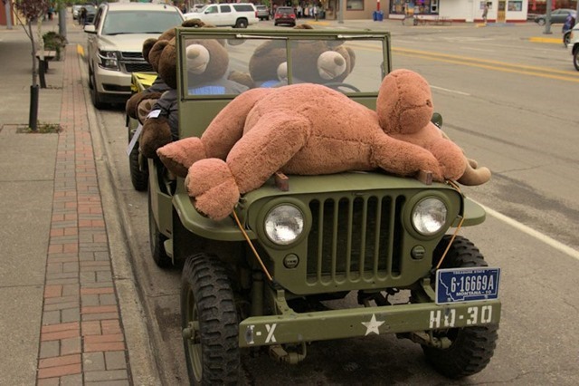 Four big teddy bears in a real jeep with a stuffed moose on the hood, West Yellowstone, Montana, August 20, 2014